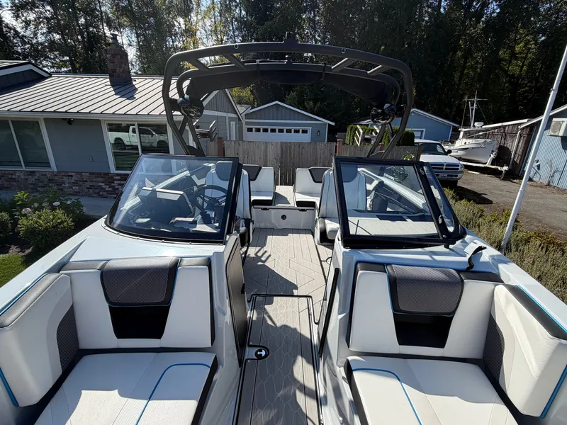 Slide: The Image of The image shows the cockpit of a 2023 Yamaha 222XE boat with modern seating and a helm. - 25