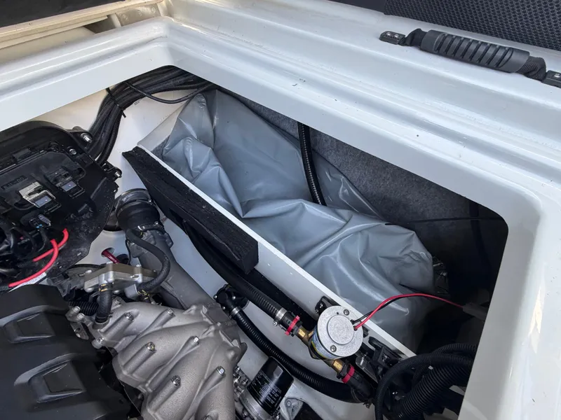 Slide: The Image of A view inside the engine compartment of a 2023 Yamaha 222XE boat, showing visible cables and components. - 28