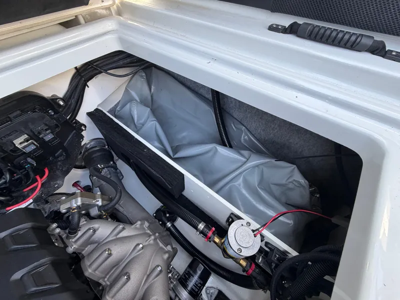 Slide: The Image of The engine compartment of a 2023 Yamaha Boats 222XE with visible wiring and components. - 27