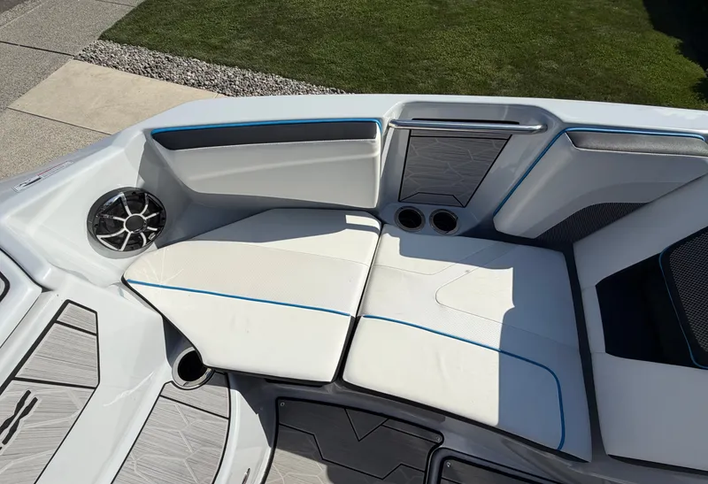 Slide: The Image of The image shows the seating area of a 2023 Yamaha 222XE boat with white upholstery and blue accents. - 23
