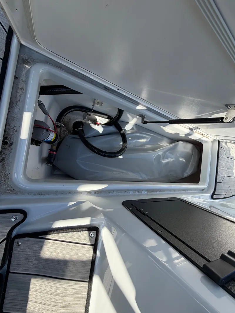 Slide: The Image of An open storage compartment on a Yamaha 222XE boat, showing cables and a gray container. - 31