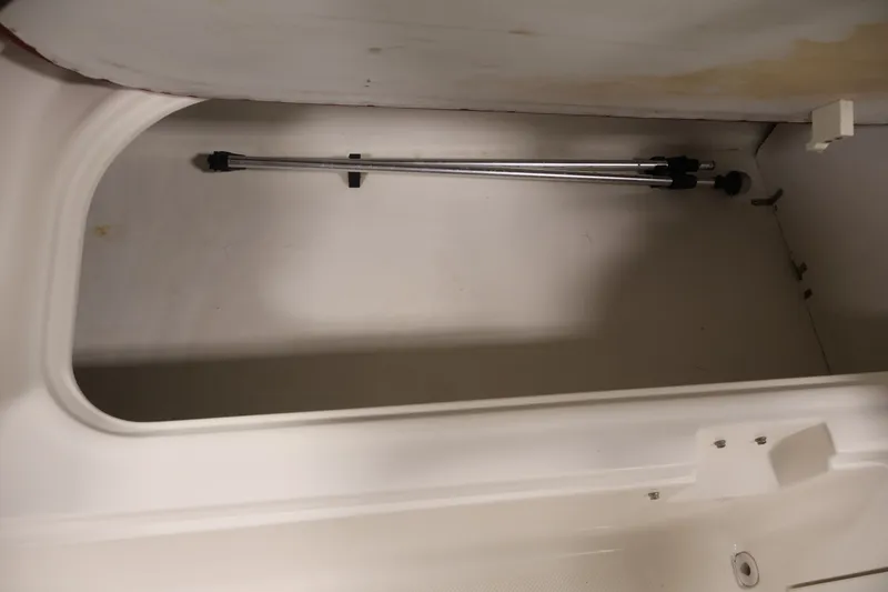 Slide: The Image of Storage compartment of a 2015 Bayliner Element 180 XL boat, featuring a metal rod. - 38