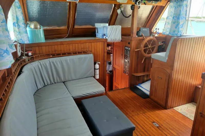 Slide: The Image of Interior of 1980 DeFever 41 Trawler with wooden helm and cozy seating area. - 5