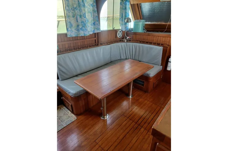 Slide: The Image of Interior of 1980 DeFever 41 Trawler with wooden table and cushioned seating. - 8