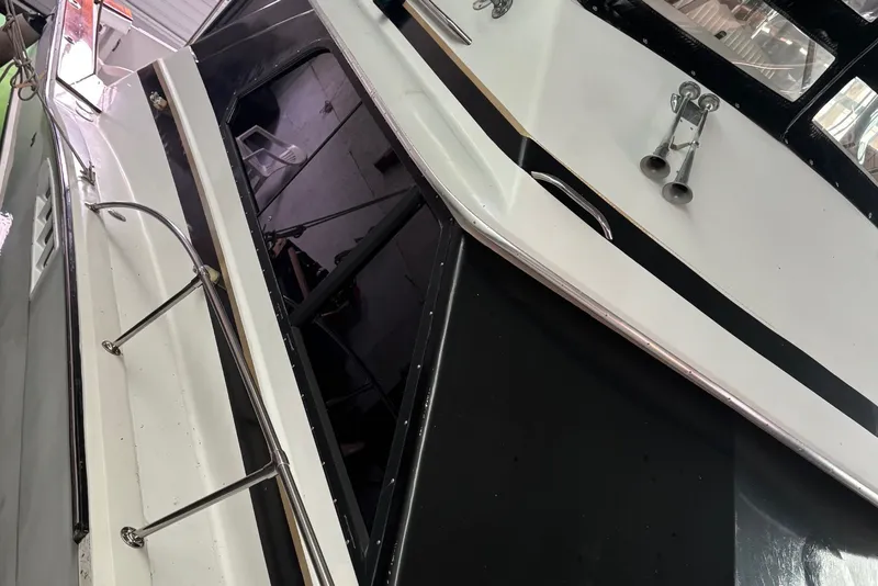 Slide: The Image of A 1988 Chris-Craft 336 Commander in a warehouse. White exterior with black accents. - 5