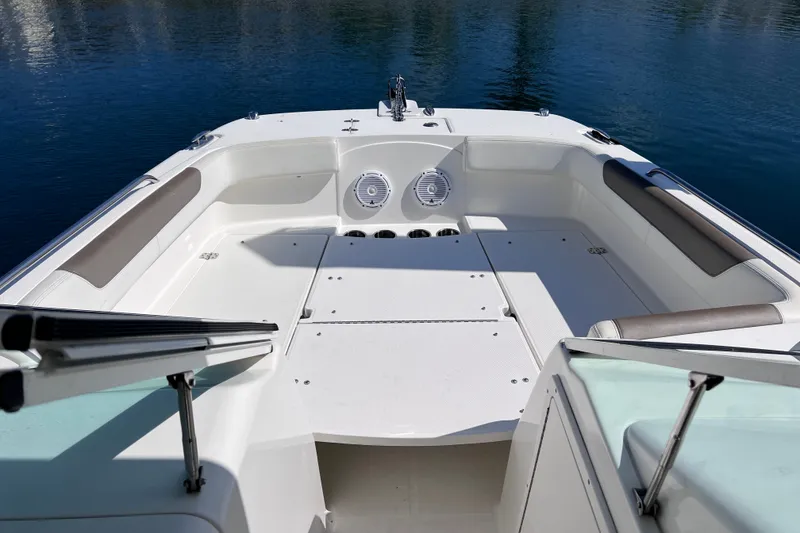 Slide: The Image of 2021 World Cat 230 DC boat interior with spacious seating and sleek design on calm water. - 19
