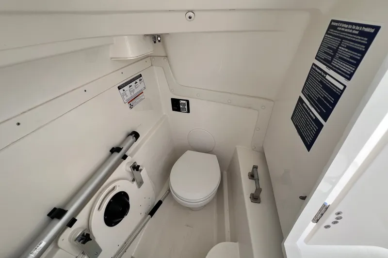 Slide: The Image of Interior of a 2021 World Cat 230 DC boat's compact bathroom with toilet and storage. - 15