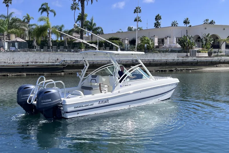 Slide: The Image of 2021 World Cat 230 DC boat cruising on water with twin Yamaha engines. - 1