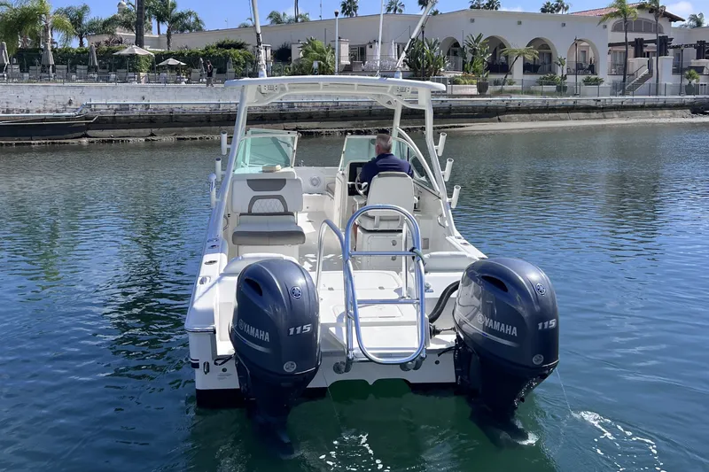 Slide: The Image of 2021 World Cat 230 DC boat with dual Yamaha 115 engines on calm water. - 8