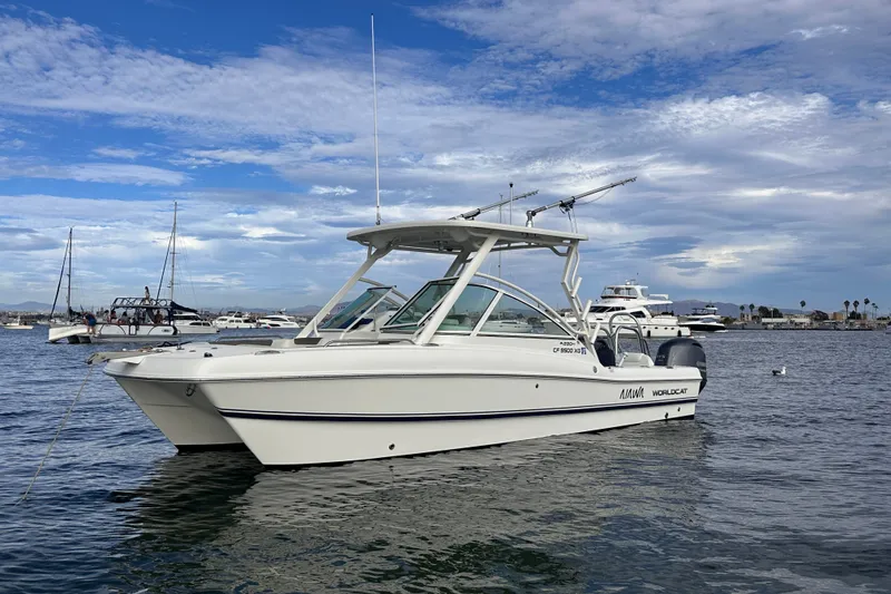 Slide: The Image of 2021 World Cat 230 DC boat on calm water under a partly cloudy sky. - 6