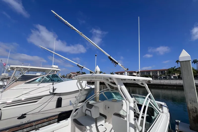 Slide: The Image of 2021 World Cat 230 DC boat docked at marina under clear blue sky. - 22
