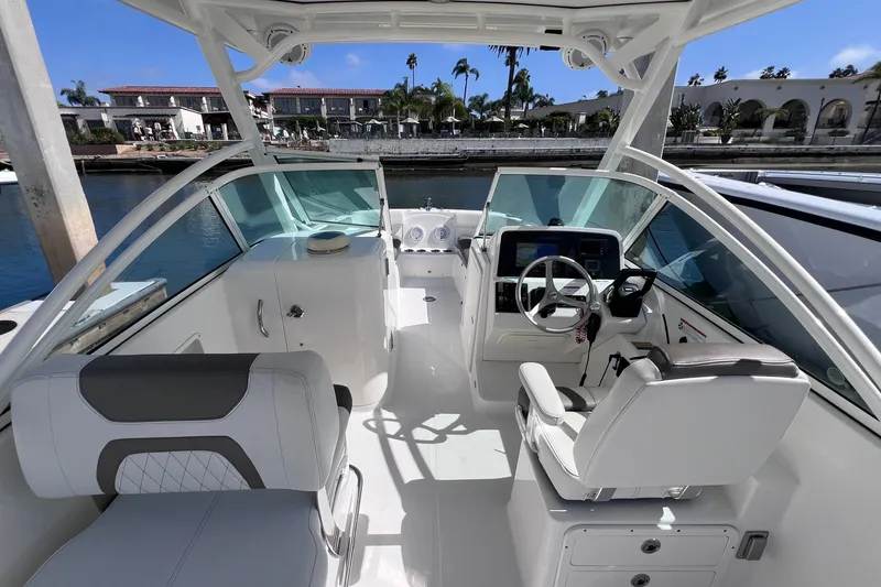 Slide: The Image of Interior view of a 2021 World Cat 230 DC boat, featuring modern seating and controls. - 10