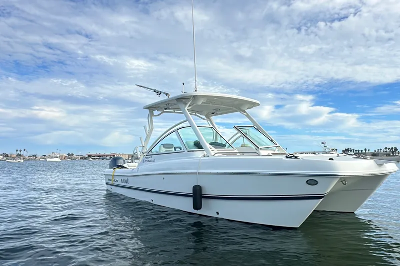 Slide: The Image of 2021 World Cat 230 DC boat on calm water under a partly cloudy sky. - 7
