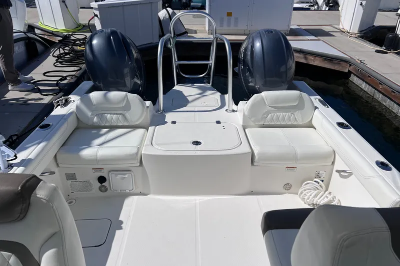 Slide: The Image of 2021 World Cat 230 DC boat interior with dual engines and white seating. - 20