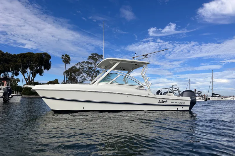 Slide: The Image of 2021 World Cat 230 DC boat on calm water under a clear blue sky. - 5
