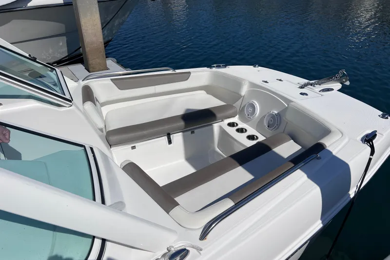 Slide: The Image of 2021 World Cat 230 DC boat interior with seating and cup holders on water. - 16