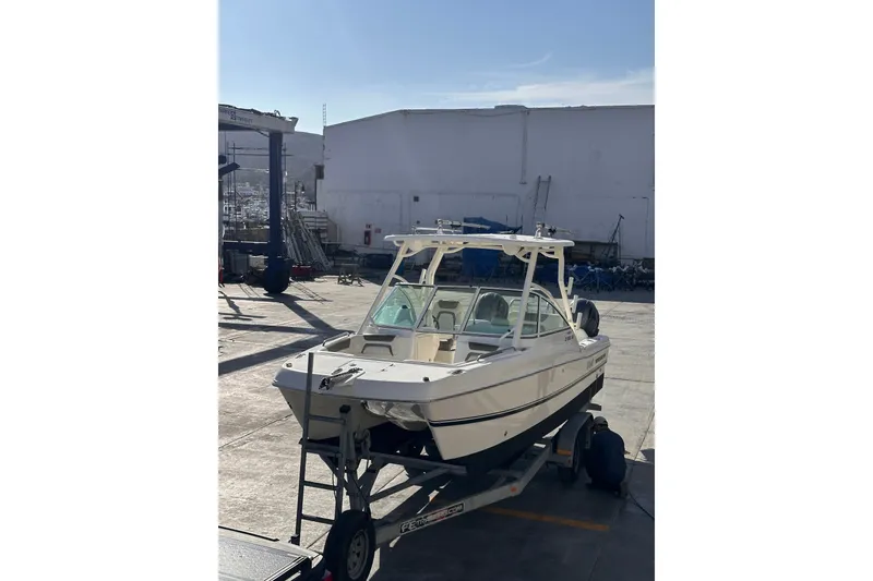 Slide: The Image of 2021 World Cat 230 DC boat on trailer in a sunny marina setting. - 23