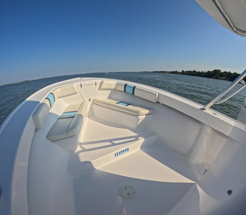 Slide: The Image of The image shows the deck of a 2018 Foster 26 boat on calm waters. - 5