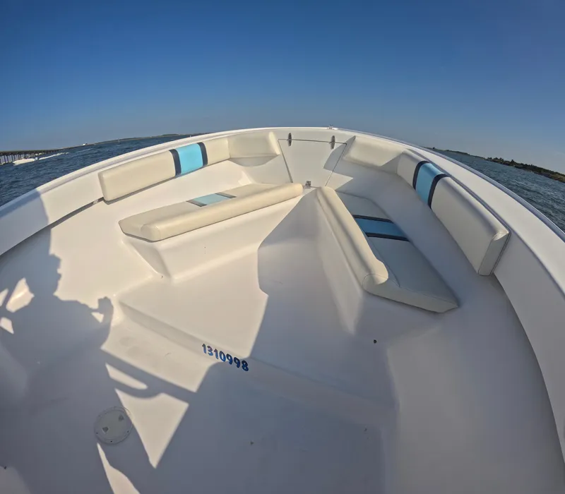 Slide: The Image of The image shows the bow of a 2018 Foster 26 boat with white and blue cushions. - 11