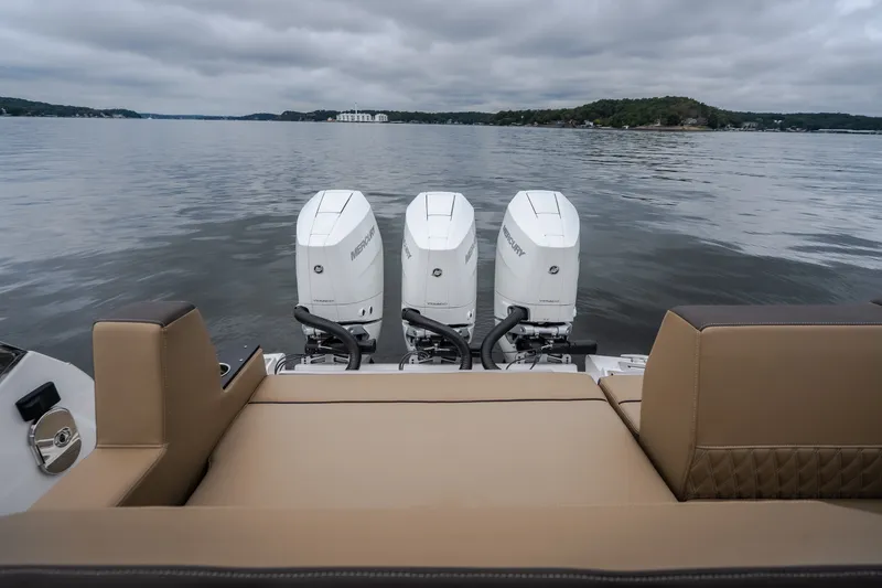 Slide: The Image of 2025 Monterey 385SS Super Sport boat with triple Mercury outboard engines on a calm lake. - 64