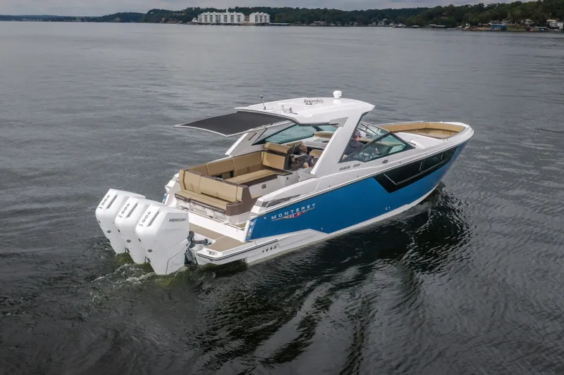 Slide: The Image of 2025 Monterey 385SS Super Sport boat cruising on a calm lake. - 2