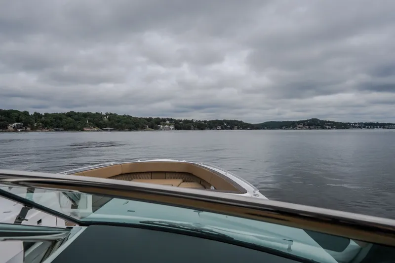 Slide: The Image of 2025 Monterey 385SS Super Sport boat cruising on a calm lake under cloudy skies. - 34