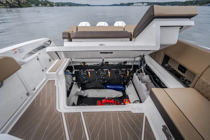 Slide: The Image of 2025 Monterey 385SS Super Sport boat interior with open engine compartment on a lake. - 58