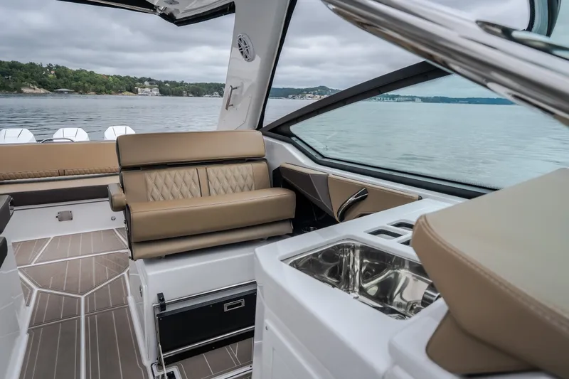 Slide: The Image of 2025 Monterey 385SS Super Sport interior with luxurious seating and sleek design on a calm lake. - 51