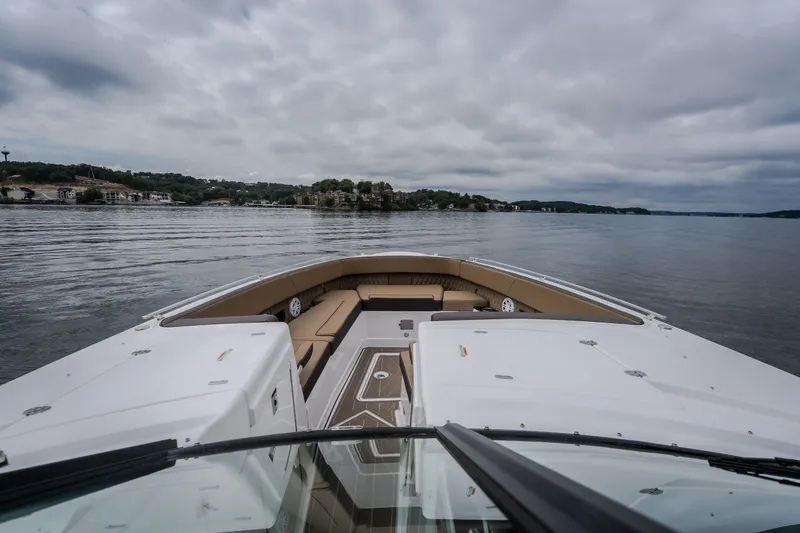 Slide: The Image of 2025 Monterey 385SS Super Sport boat on calm waters under cloudy skies. - 38