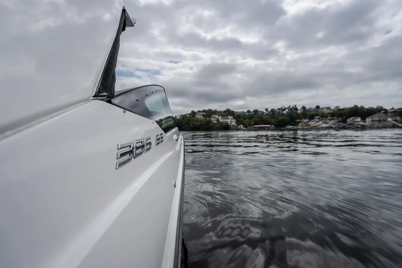 Slide: The Image of 2025 Monterey 385SS Super Sport boat on calm water under cloudy sky. - 32