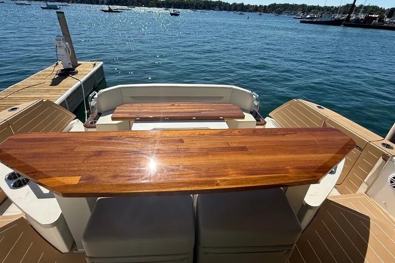 Slide: The Image of Tiara Yachts EX 54 (2026) with polished wooden deck overlooking serene waters. - 7