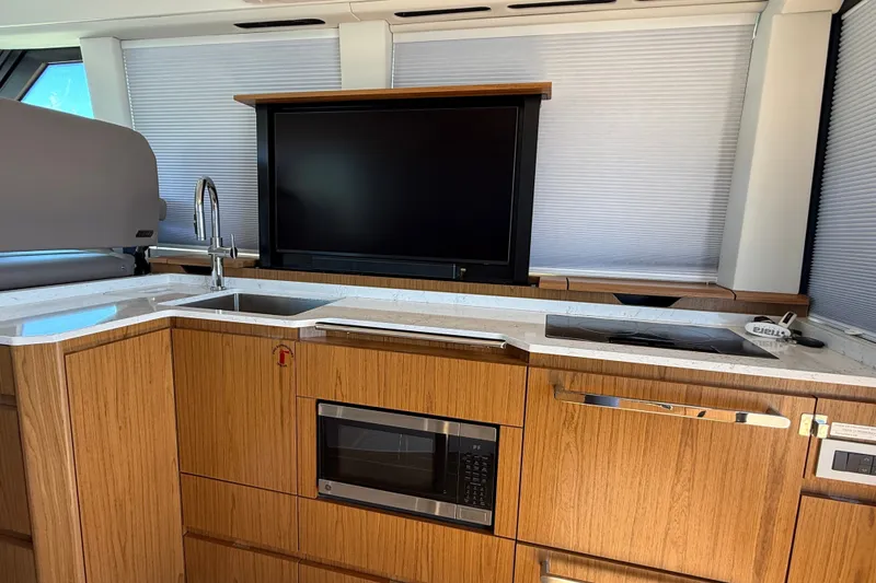 Slide: The Image of Modern kitchen interior of 2026 Tiara Yachts EX 54 with sleek appliances and wood cabinetry. - 12