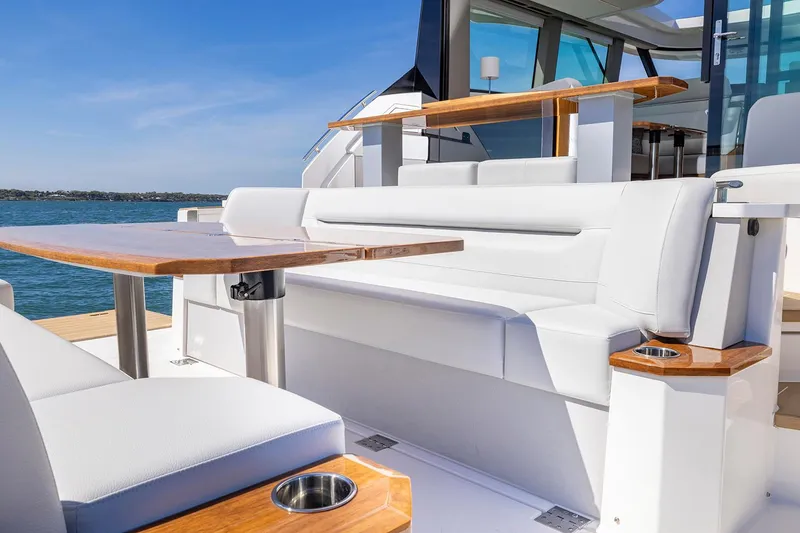 Slide: The Image of Manufacturer Provided Image: Luxurious seating area on 2025 Tiara Yachts EX 54, featuring elegant white upholstery and wooden accents. - 47