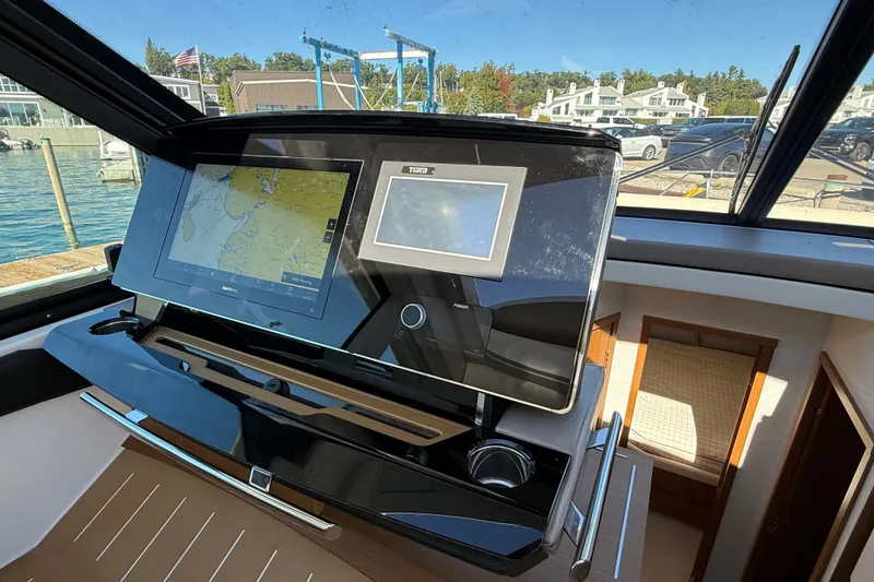 Slide: The Image of Helm of 2026 Tiara Yachts EX 54 with advanced navigation displays and controls. - 19