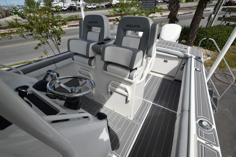 Slide: The Image of The image shows the cockpit of a 2018 Regulator 28 Forward Seating boat with two cushioned seats. - 8