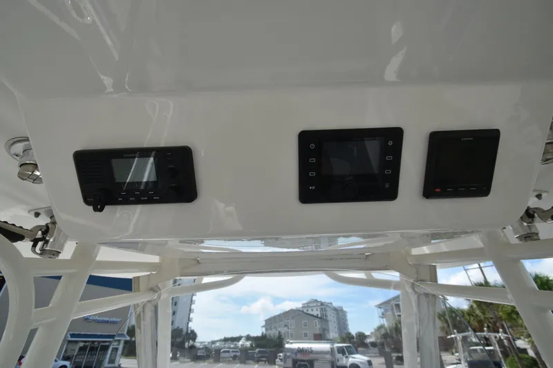 Slide: The Image of The image shows the helm of a 2018 Regulator 28 Forward Seating boat with electronic displays. - 13