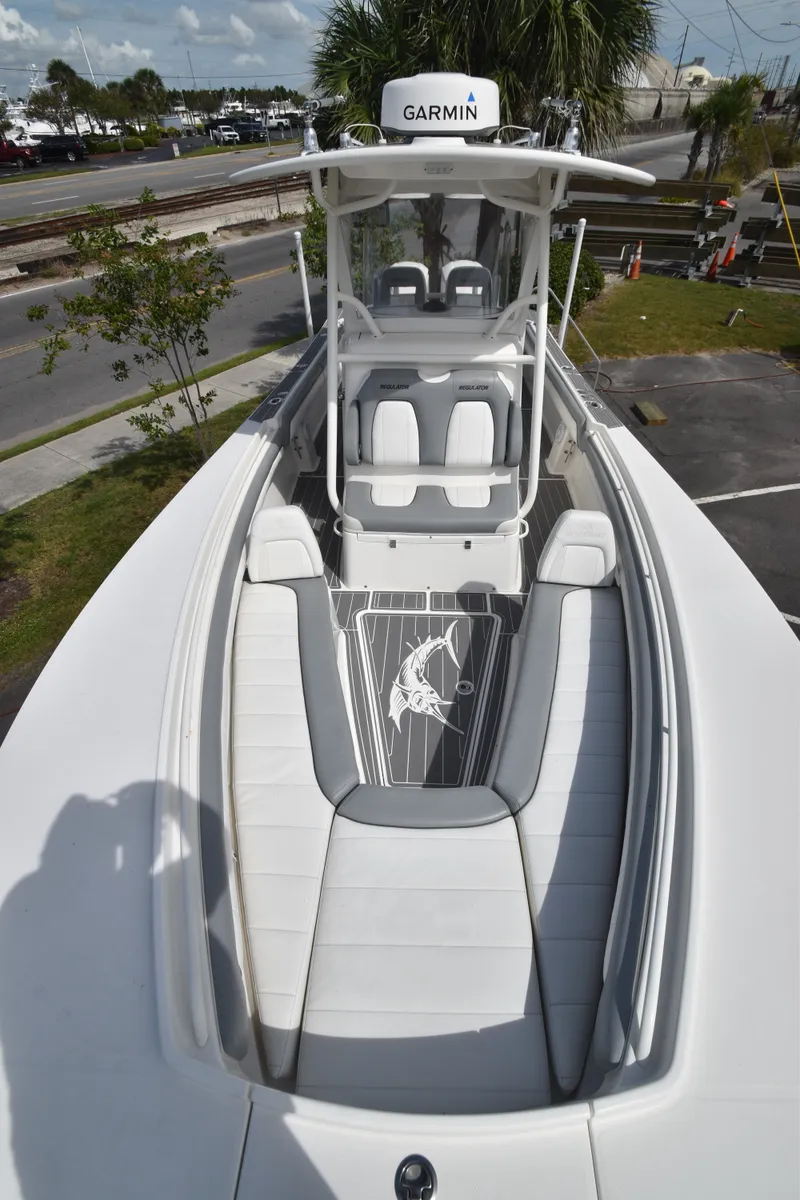 Slide: The Image of The image shows the bow of a 2018 Regulator 28 Forward Seating boat with white upholstery and a Garmin device. - 7