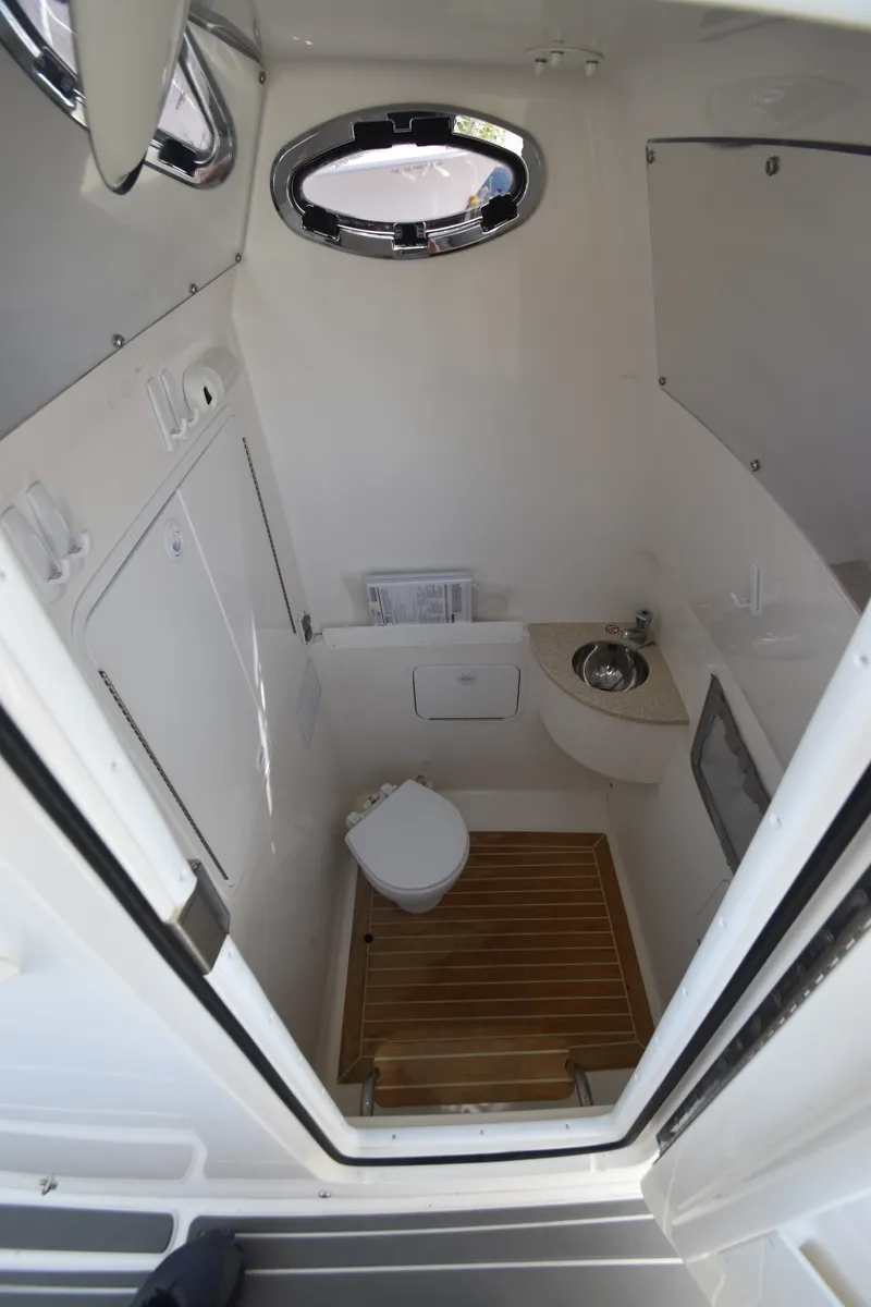 Slide: The Image of The image shows a compact boat cabin with a toilet, sink, and wooden flooring. - 5