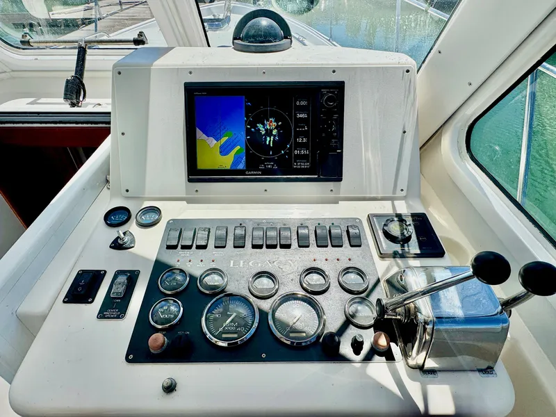 Slide: The Image of The image shows the helm of a 2003 Legacy 34 Express with instruments and control levers. - 18
