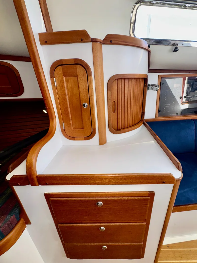 Slide: The Image of Interior of a 2003 Legacy 34 Express with elegant wooden cabinetry and blue upholstery. - 33