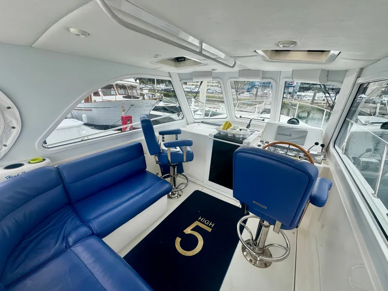 Slide: The Image of Interior of a 2003 Legacy 34 Express with blue seating and a steering wheel. - 16