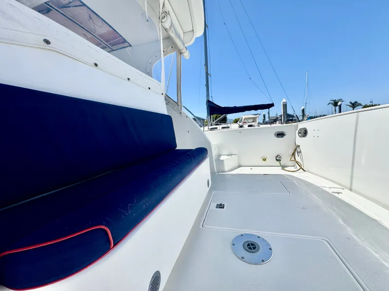 Slide: The Image of The image shows the deck of a 2003 Legacy 34 Express boat with blue seat cushions. - 14