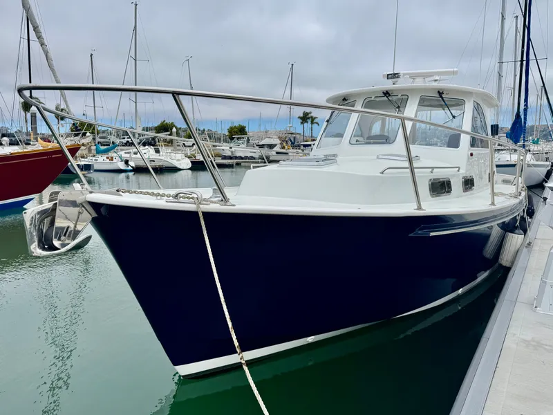 Slide: The Image of A 2003 Legacy 34 Express boat docked in a marina. It features a blue hull design. - 3