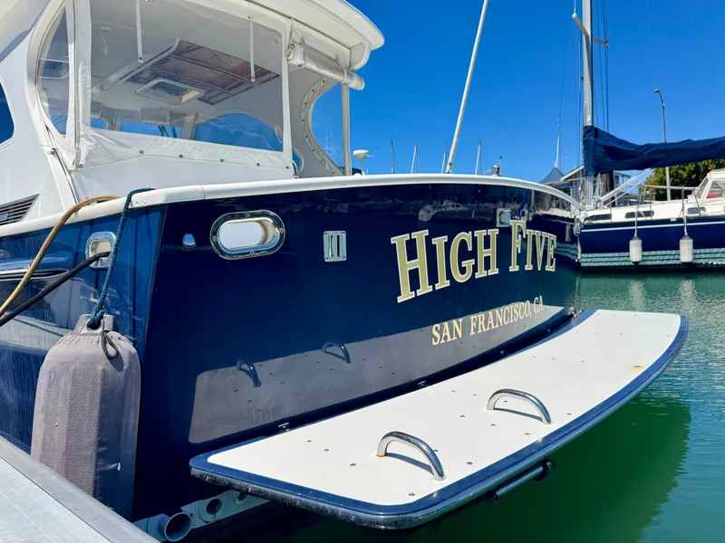 Slide: The Image of The image shows a blue boat named "High Five" docked in a marina. - 13