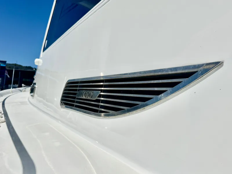 Slide: The Image of Close-up of a 2003 Legacy 34 Express with a shiny metal accent on a white hull. - 6