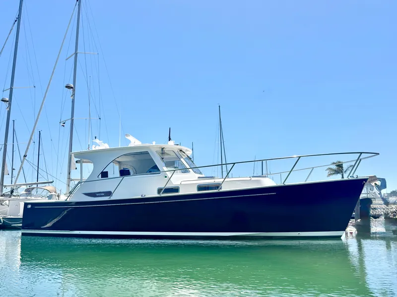 Slide: The Image of A sleek blue boat docked in the harbor, featuring a white superstructure and clear blue sky. - 1