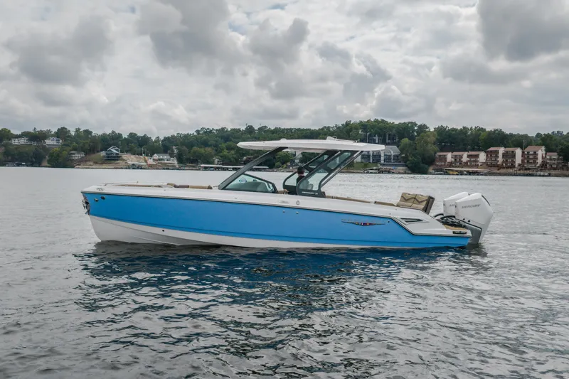 Slide: The Image of 2026 Monterey Elite 30 OB boat on a calm lake under cloudy skies. - 64