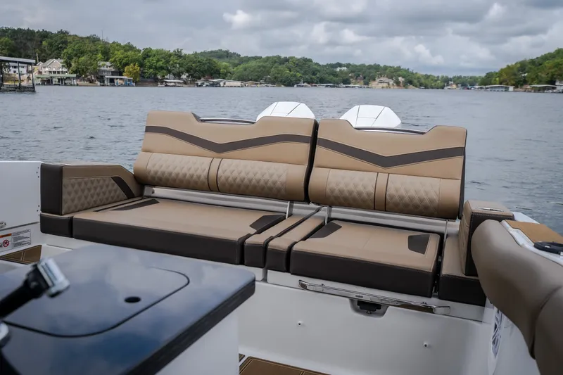 Slide: The Image of 2026 Monterey Elite 30 OB boat with luxurious seating on a scenic lake. - 44