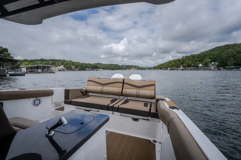Slide: The Image of 2026 Monterey Elite 30 OB boat interior with luxurious seating on a scenic lake. - 43