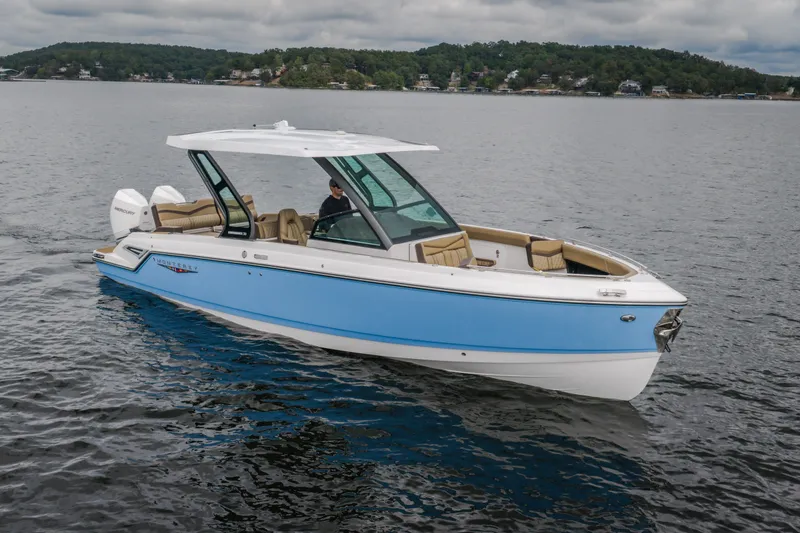 Slide: The Image of 2026 Monterey Elite 30 OB boat cruising on a lake with scenic background. - 1